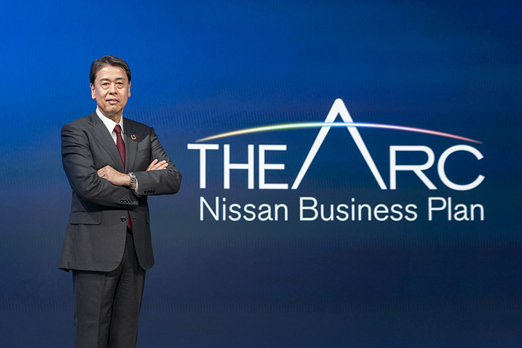 Makoto Uchida, CEO de Nissan, parado junto al logo de The Arc Business Plan